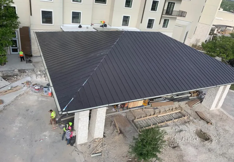 Metal roofing installation team working on a commercial building in Trinidad